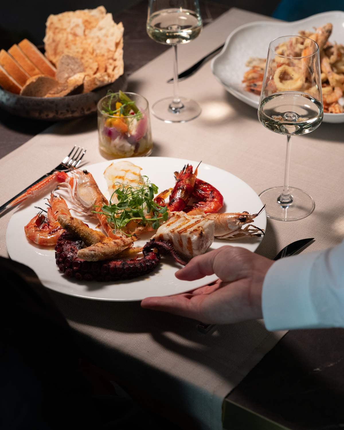 Una portata di mare servita al tavolo apparecchiato di Bontade Bistrot