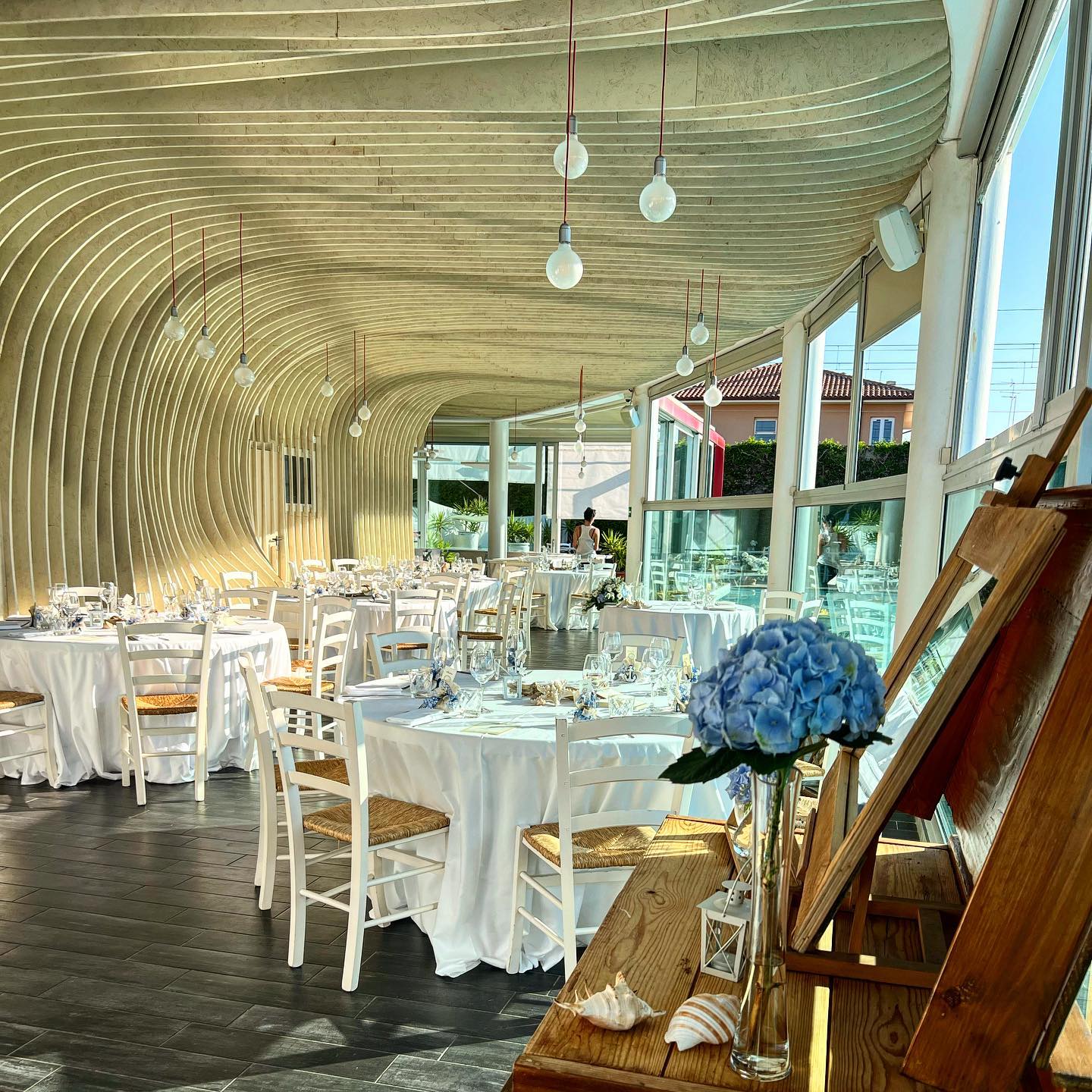 La sala di Acquapazza apparecchiata per una cerimonia, con tavoli e decorazioni floreali