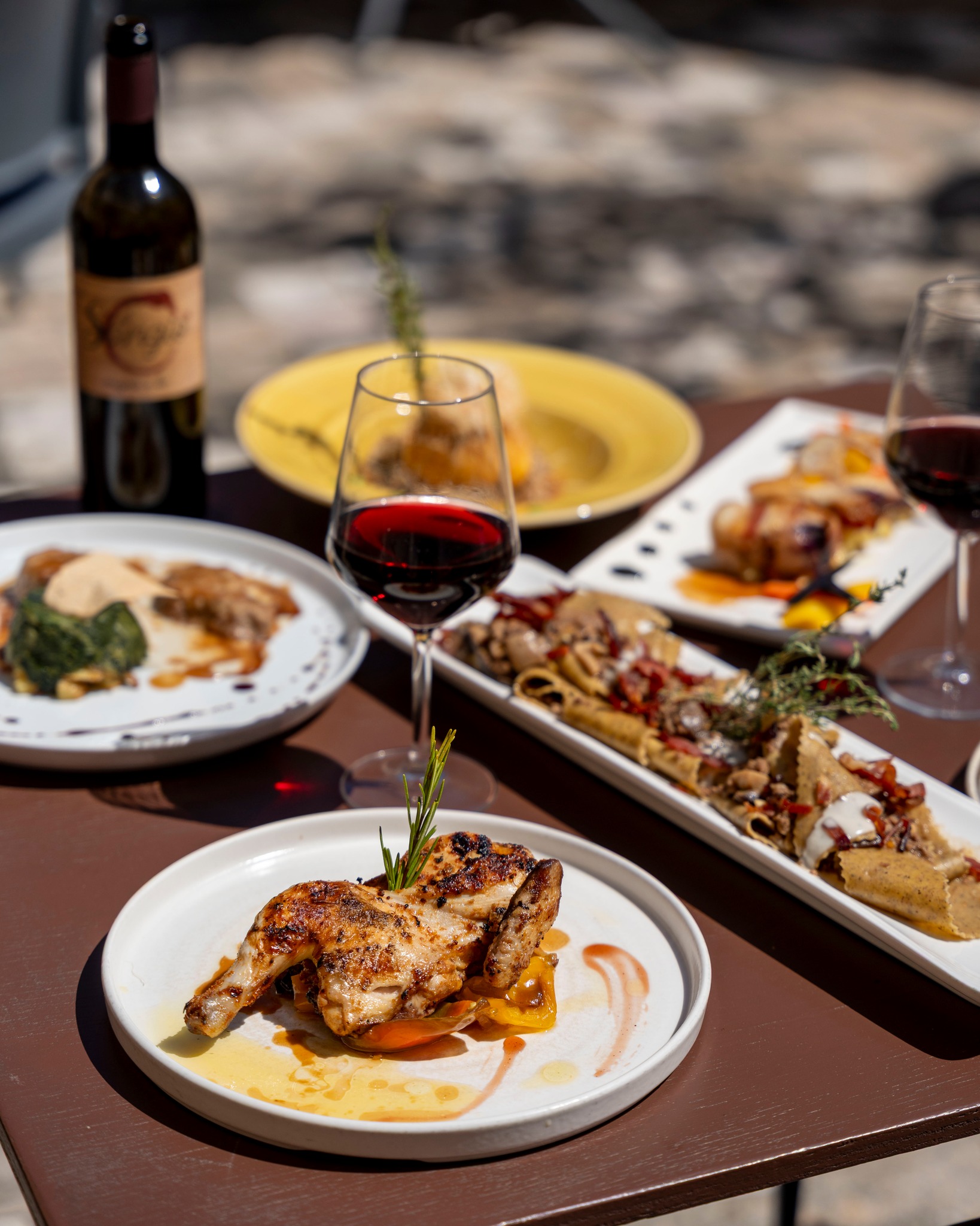 Tavola con pollo, antipasti e vino rosso