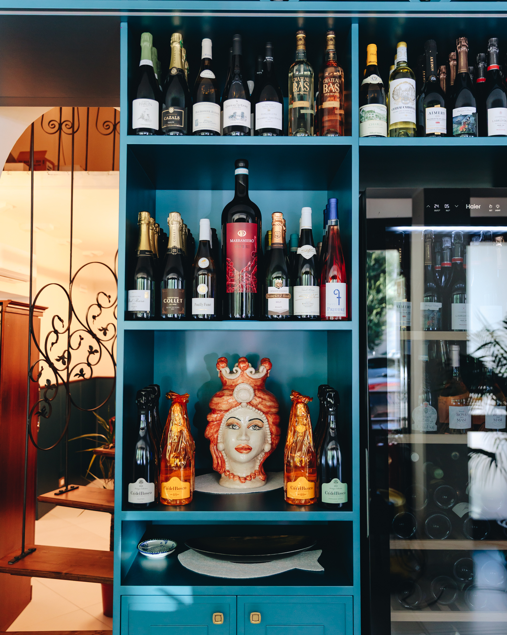 La selezione di vini nelle scaffalature blu dell'Antico Borgo