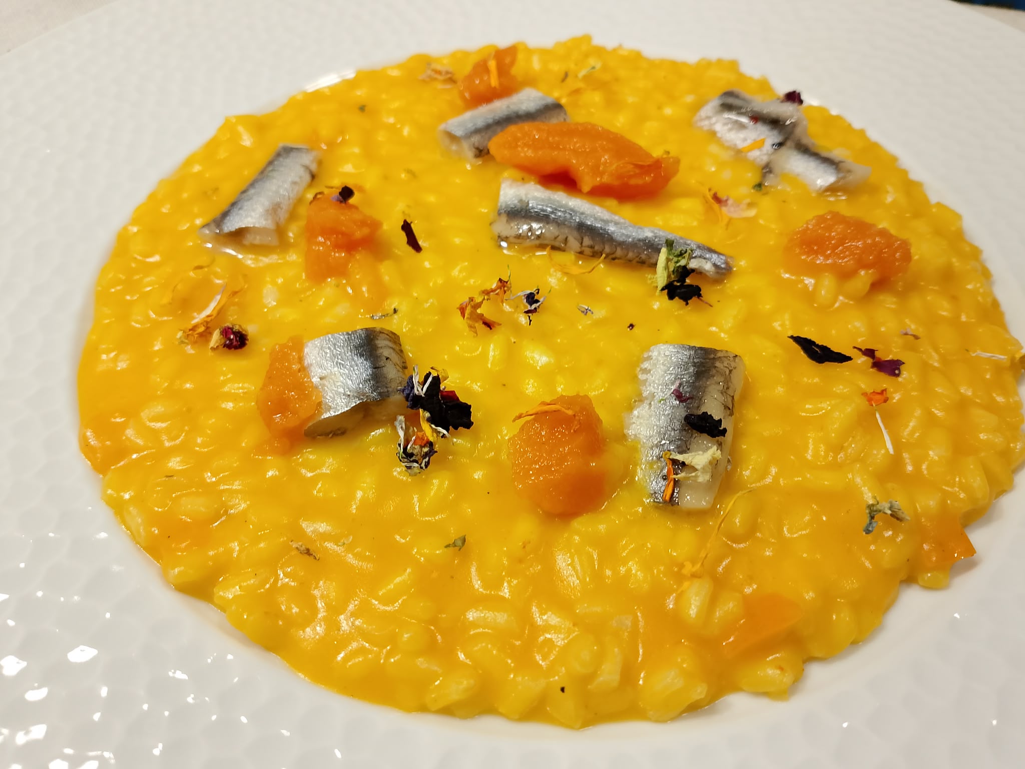 Risotto di mare con una presentazione dorata