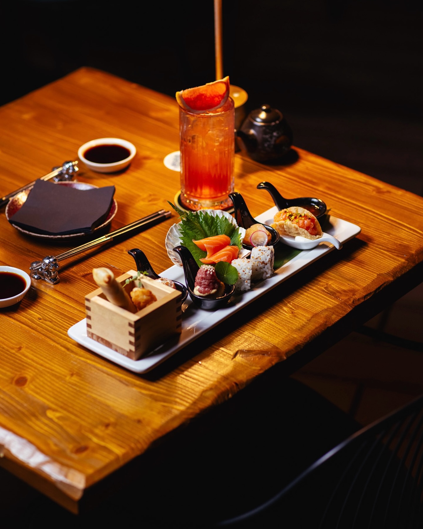 Tavolo in legno con cocktail e selezione fusion