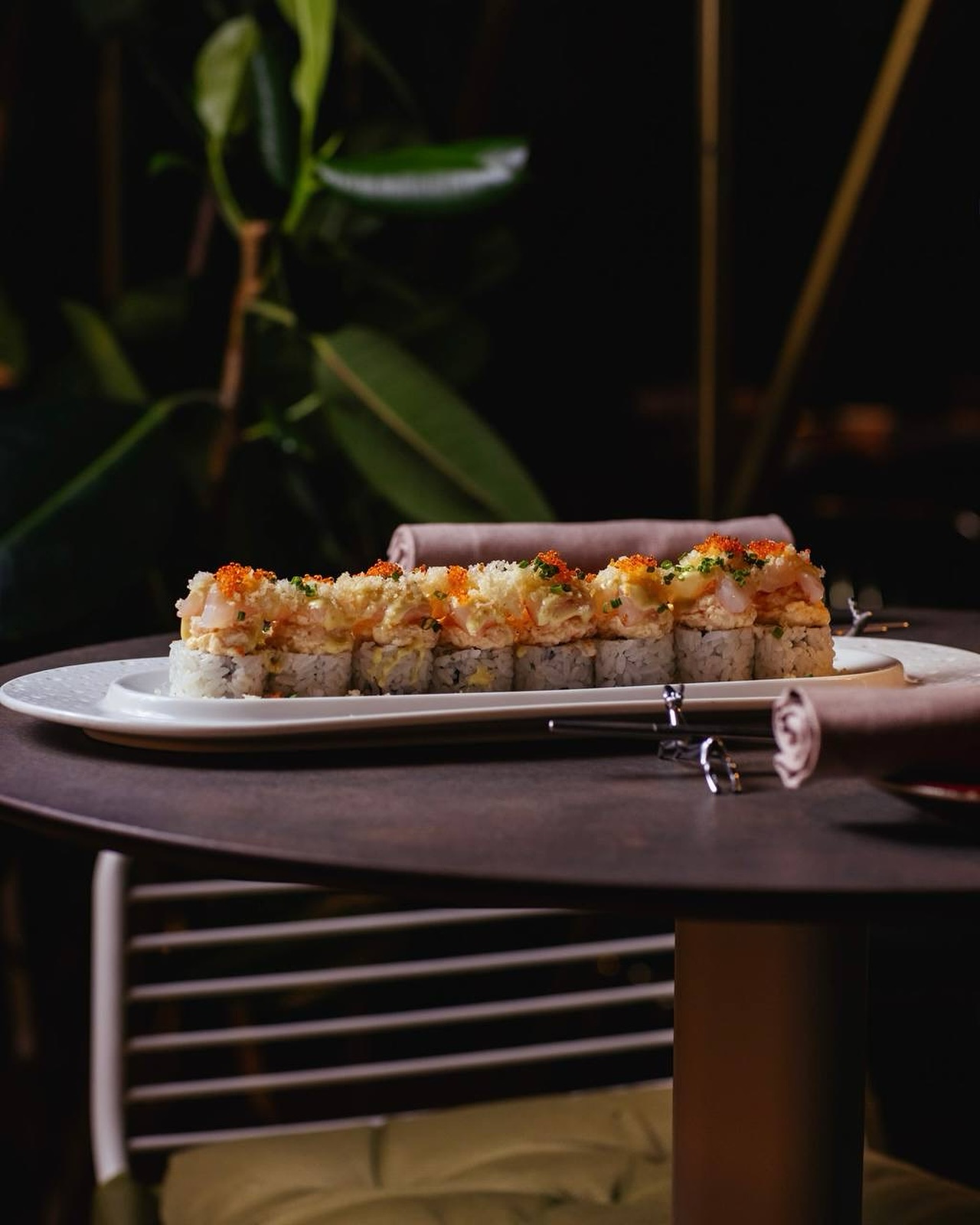 Roll di sushi servito al tavolo tra le piante