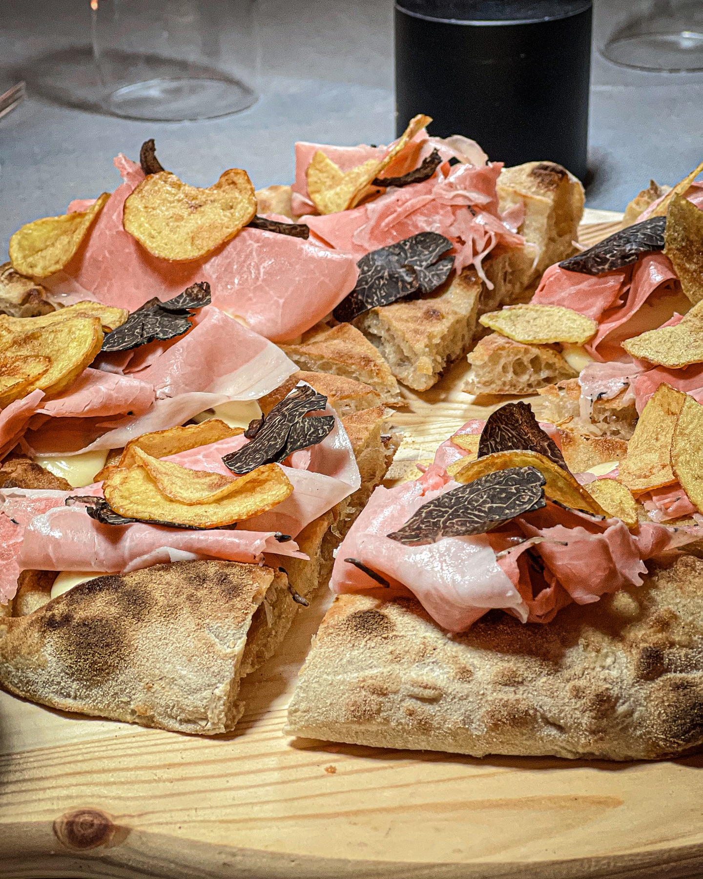 Una proposta de La Dolce Vita con mortadella, tartufo e chips di patate, servita su un tagliere