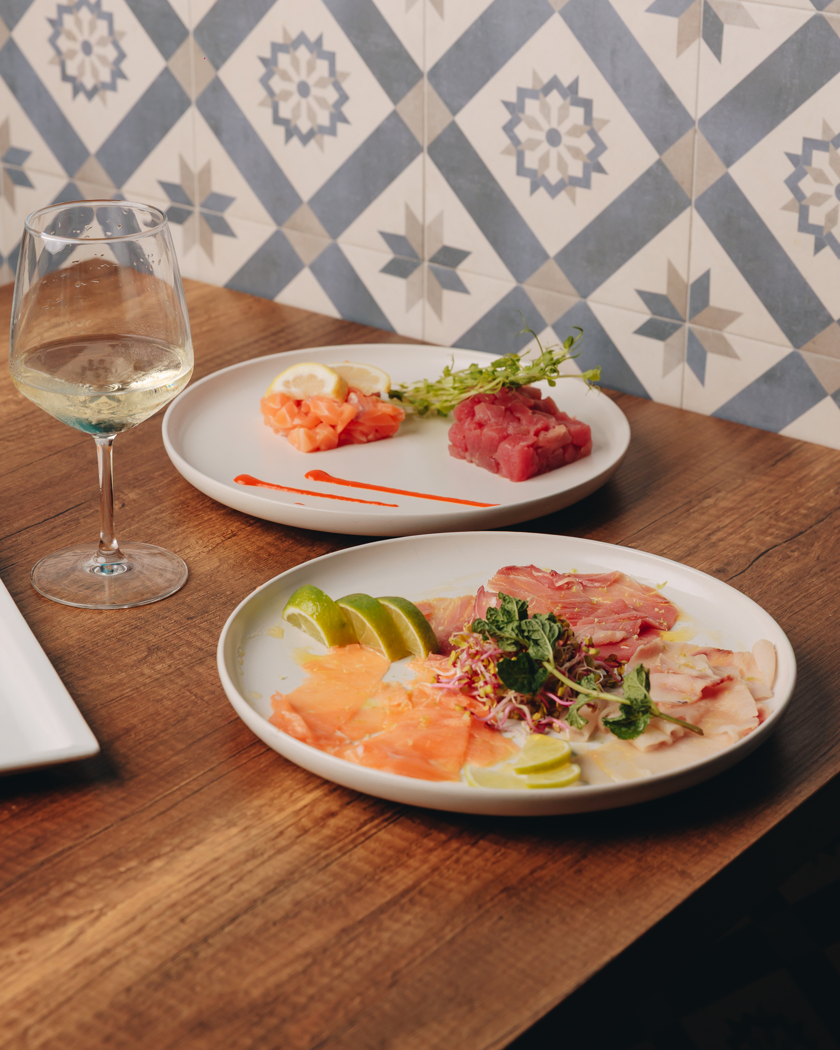 Tartare di tonno e crudi di pesce serviti con un calice di vino
