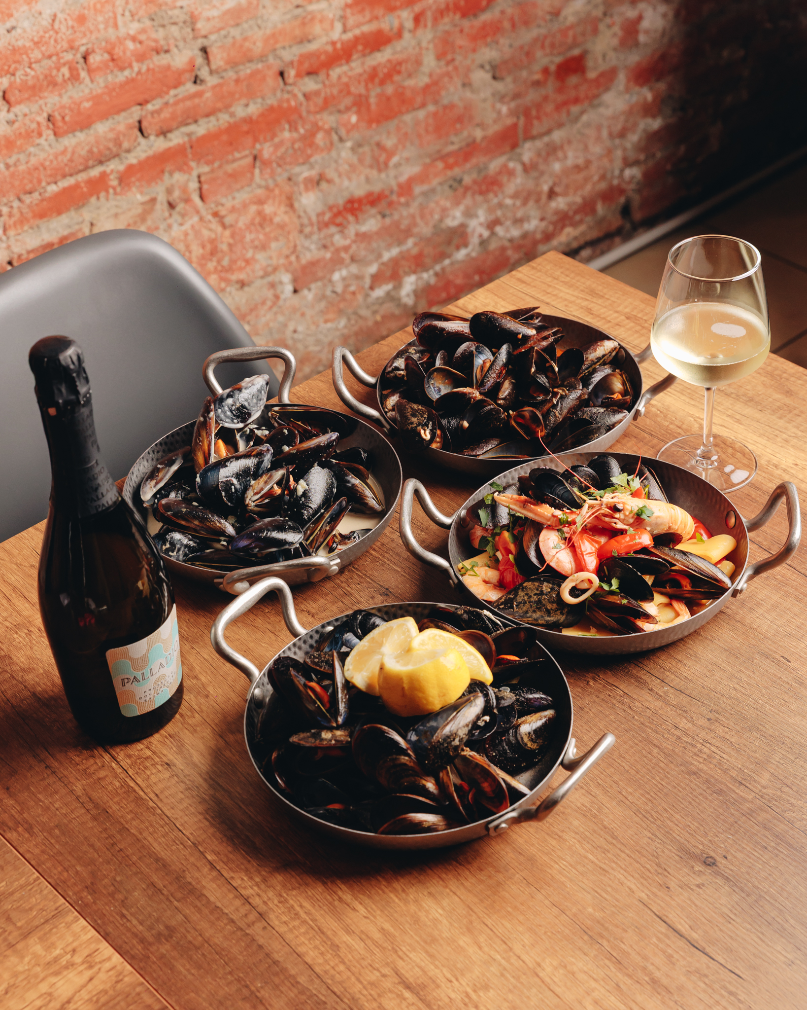 Cozze e frutti di mare serviti in padelle sul tavolo