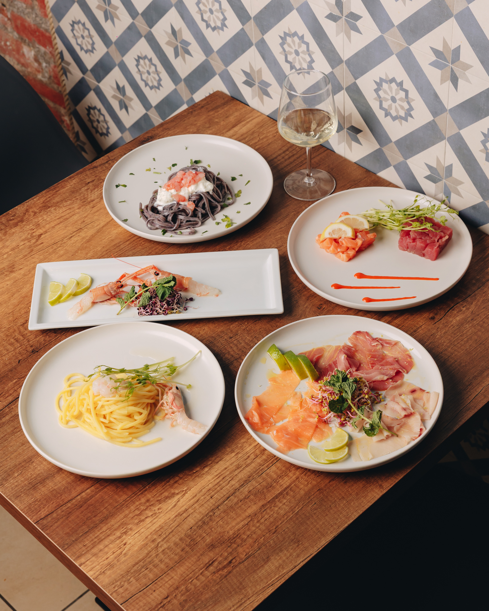 Selezione di piatti di mare, crudi e pasta, su un tavolo del ristorante
