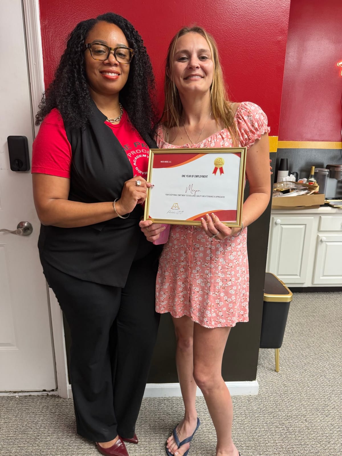 A Mack Maids team member receiving a one-year employment certificate