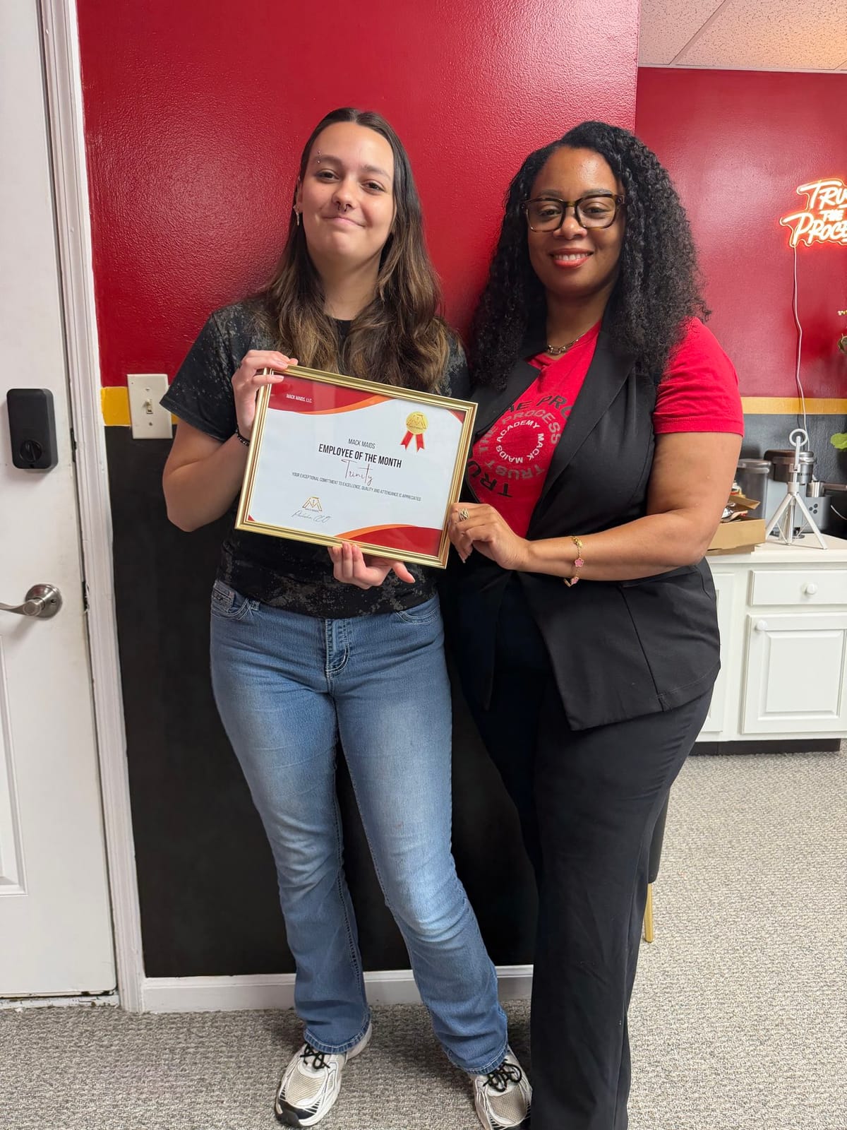 A Mack Maids team member receiving an Employee of the Month certificate