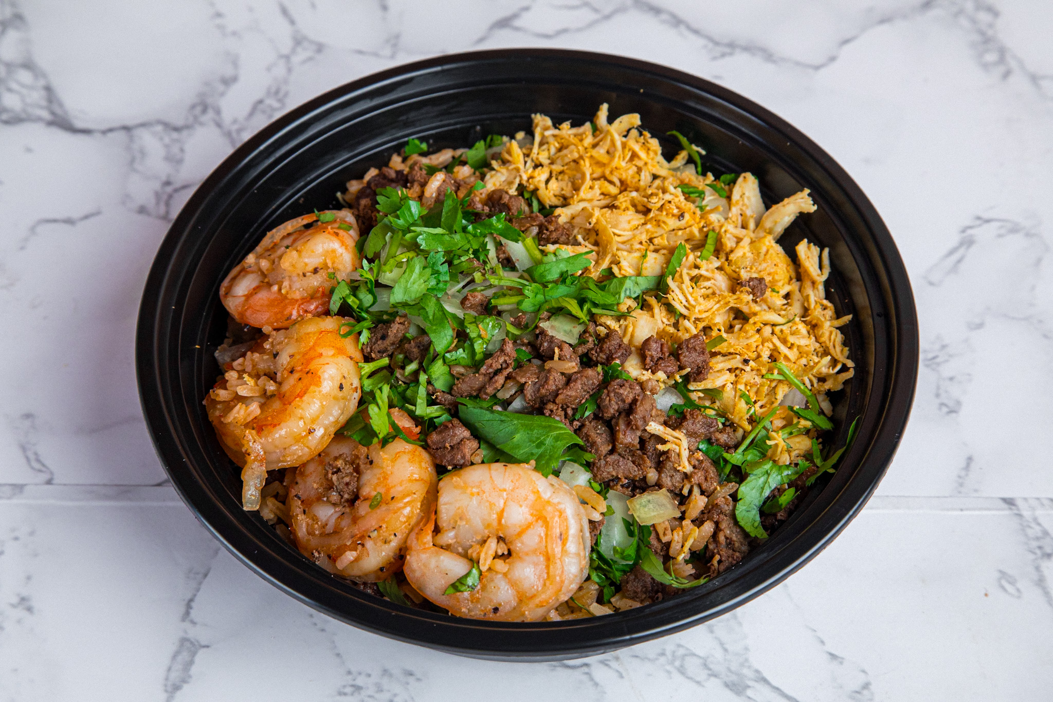 Taco Mell steak and shrimp burrito bowl with rice, beans, and fresh toppings