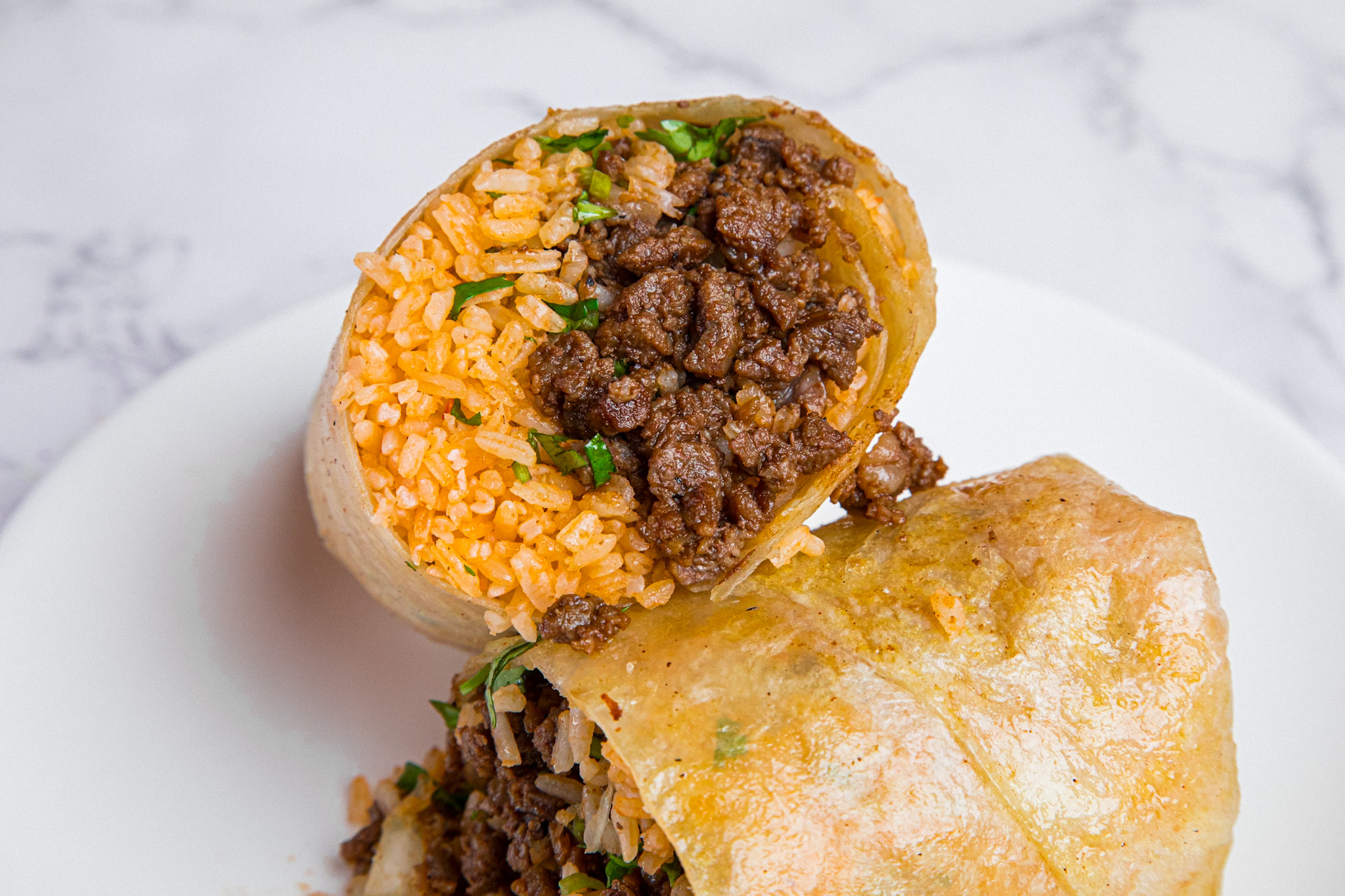 Taco Mell steak burrito cross-section — tray-style office lunch catering