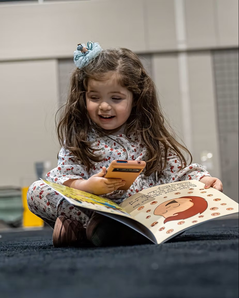 Toddler engaging with an AR book with a mobile device