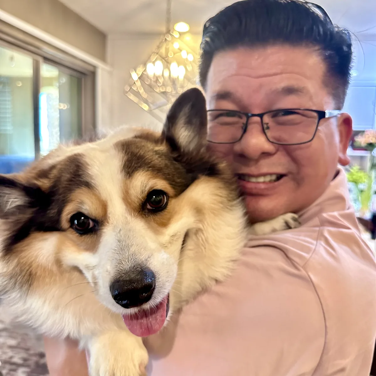 Anthony holding Mina, his corgi, cheek to cheek