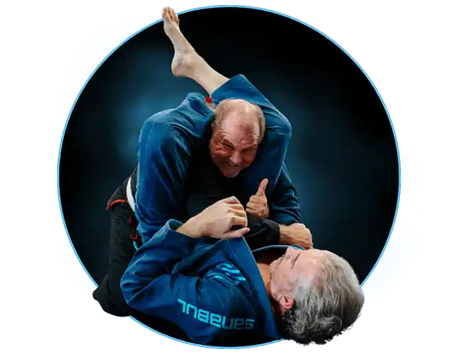 Two older men wearing Brazilian Jiu Jitsu Gis practicing a triangle submission technique during a class at Stadium MMA in Port Orange, Florida.