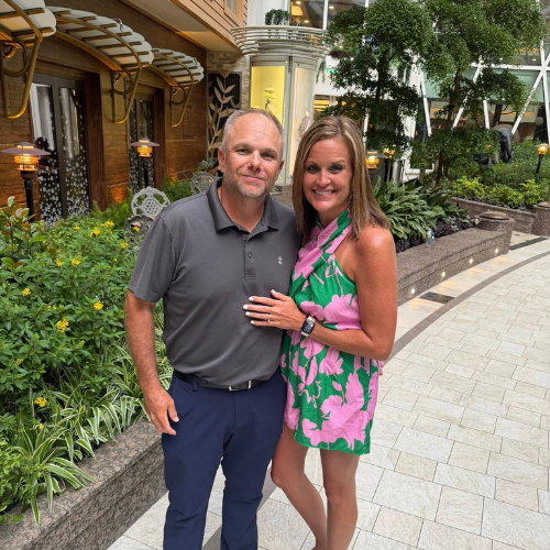 A young couple standing outside a restaurant on a cruise ship.