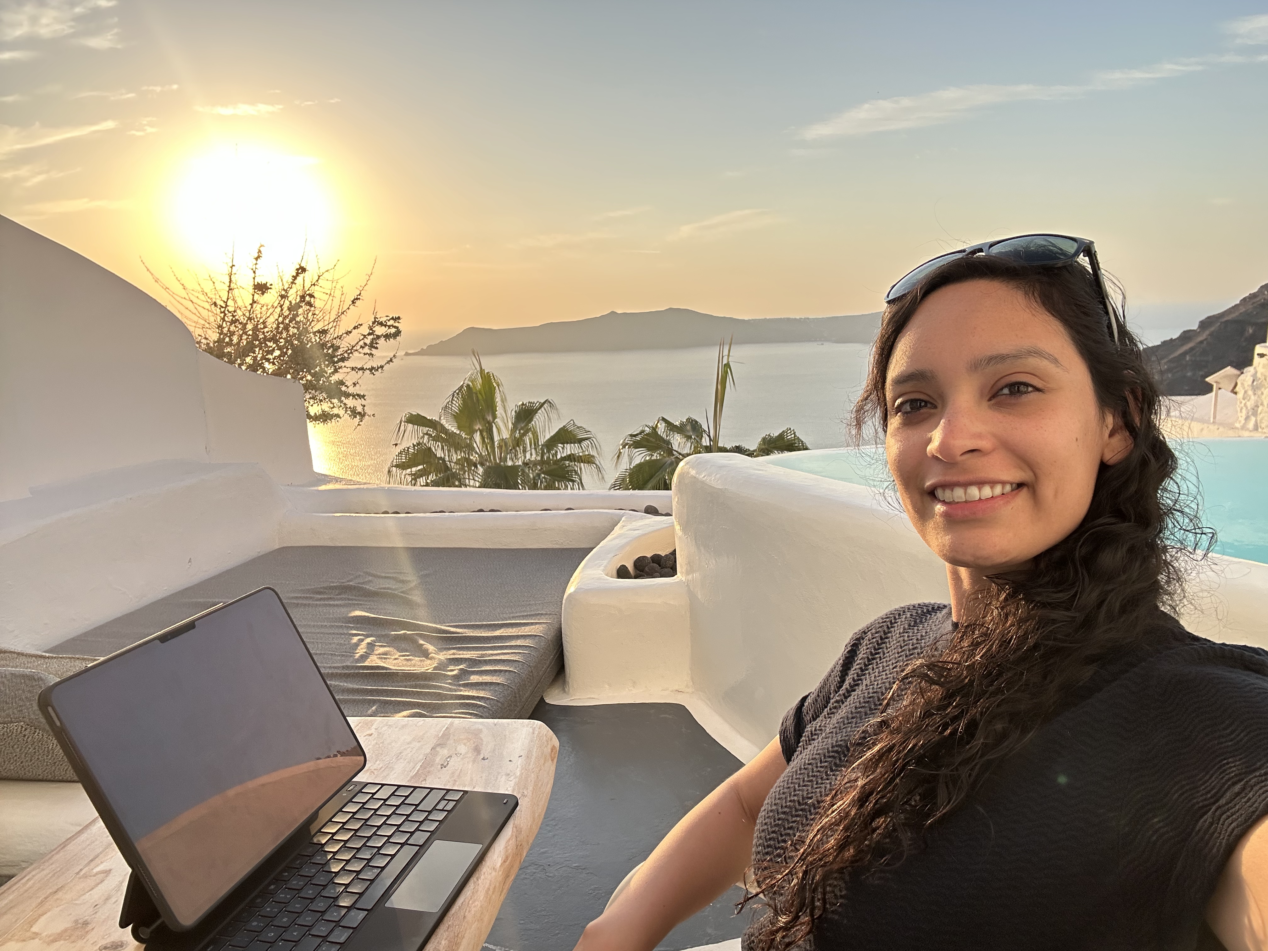 Mel Cobian working from a beautiful terrace overlooking the ocean at sunset