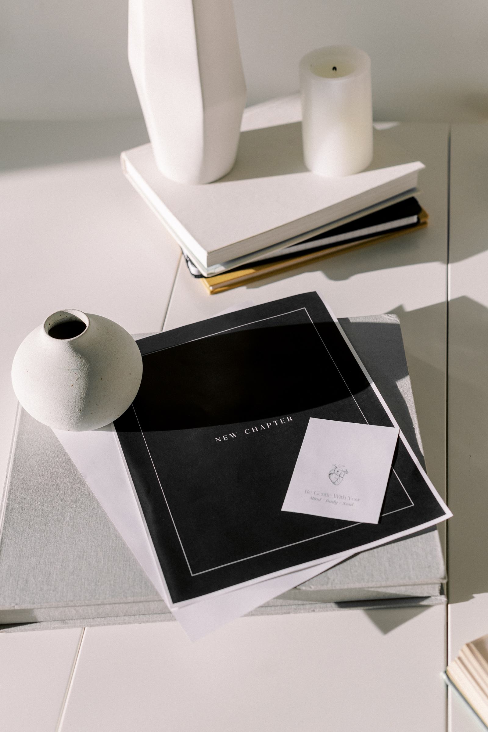 Minimal flatlay with a ‘New Chapter’ booklet and neutral decor, symbolizing strategy, systems, and supportive business growth.