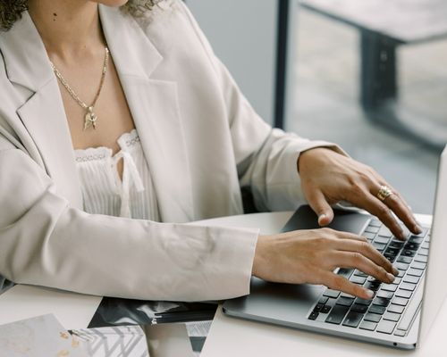 Woman working on a laptop, representing done-for-you marketing and operations support.