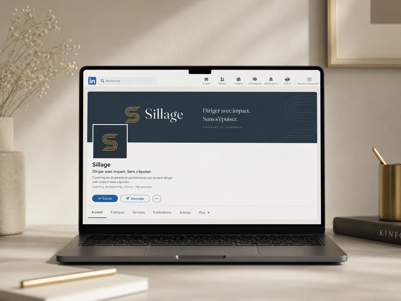 Page LinkedIn du Sillage sur un ordinateur portable : bannière ardoise avec la phrase « Diriger avec impact. Sans s'épuiser. » et symbole S en photo de profil.
