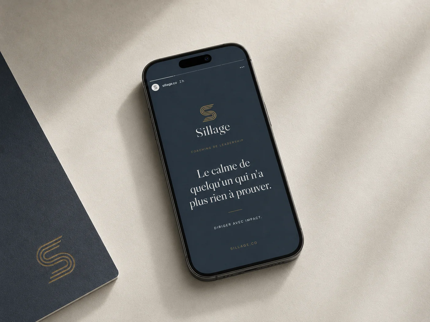 Publication Instagram du Sillage sur un téléphone : logo secondaire empilé et phrase « Le calme de quelqu'un qui n'a plus rien à prouver » sur fond ardoise.