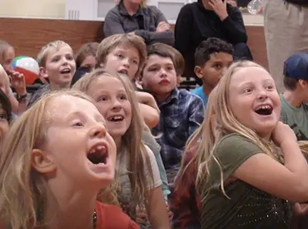 Students reacting with amazement during a Denver school magic show