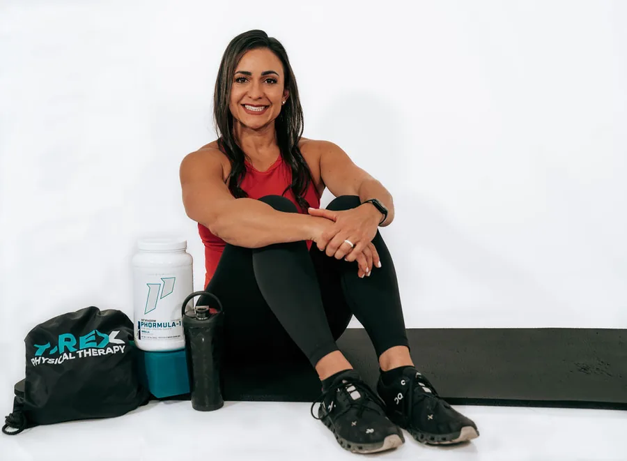 Dr. Christina seated beside a protein shaker and training bag