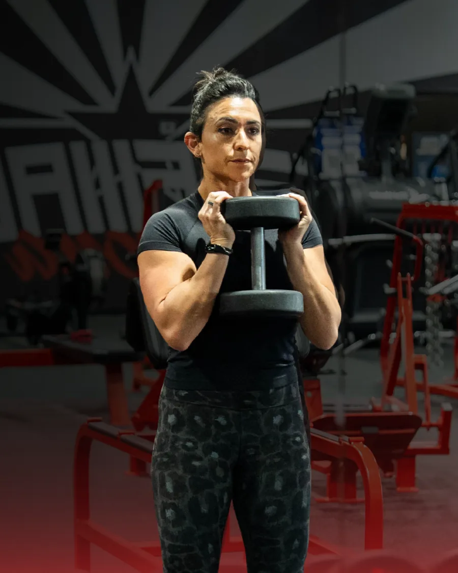 Dr. Christina training with a dumbbell at the gym