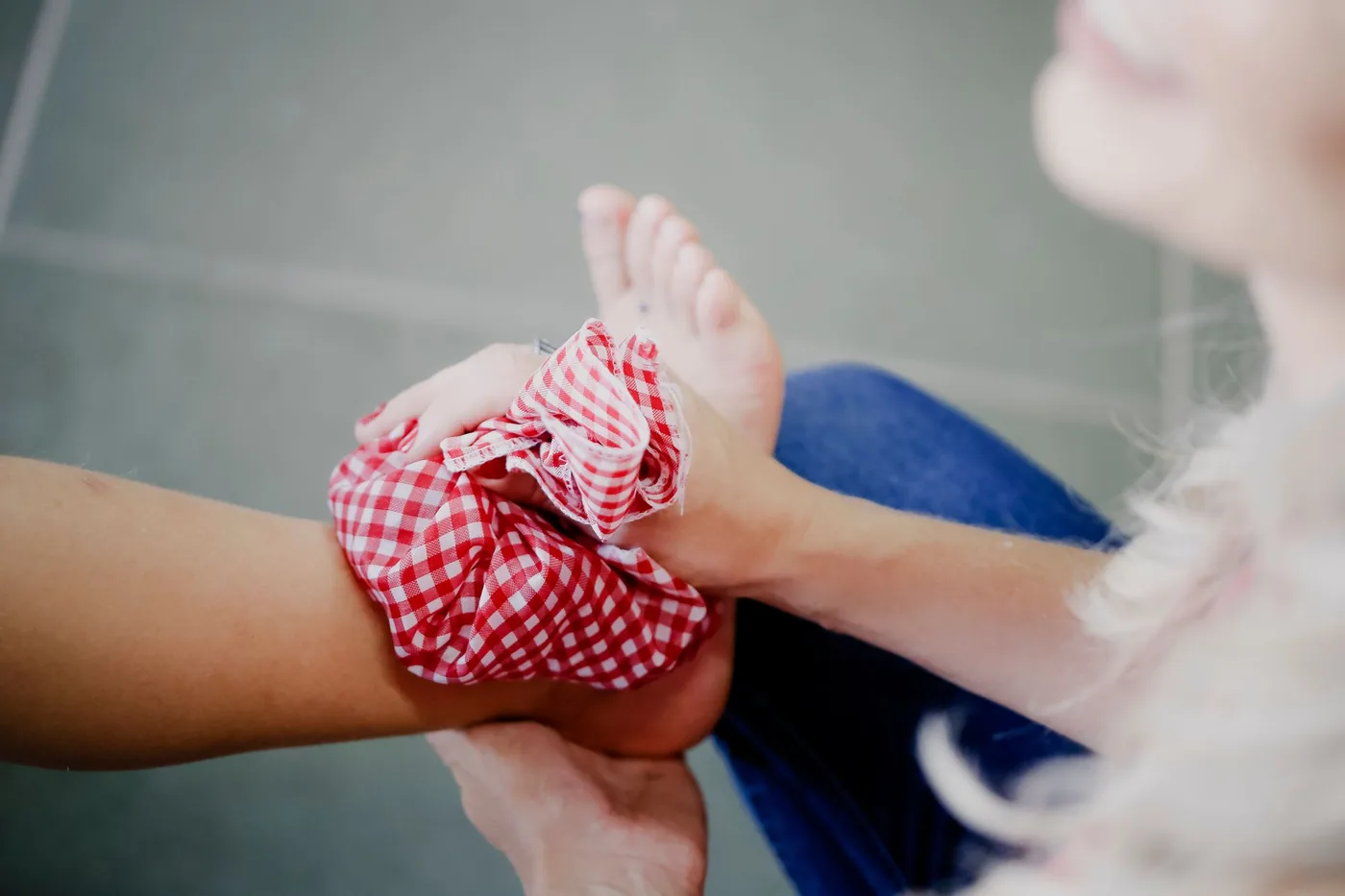 A checkered ice pack held against a bare ankle