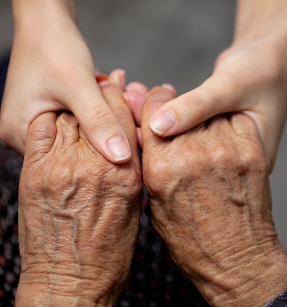 young woman and old woman holding hands