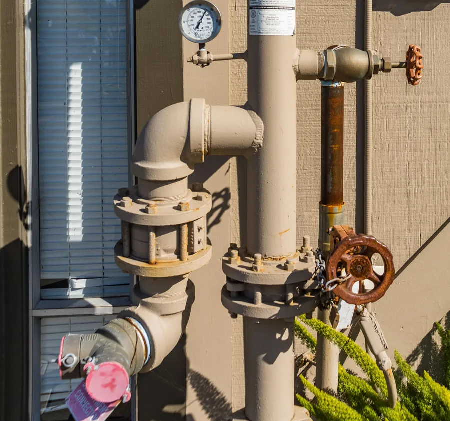 Exterior water line with flanged fittings, gate valves and a pressure gauge