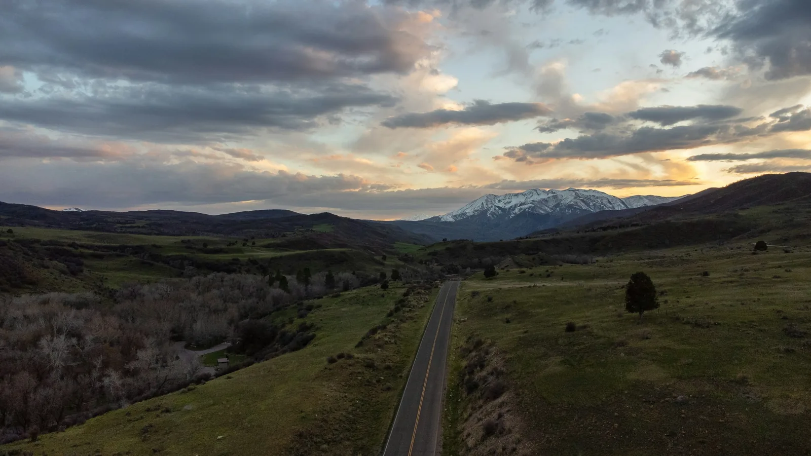 Aerial view of a rural road through fields and foothills near Spanish Fork, Utah