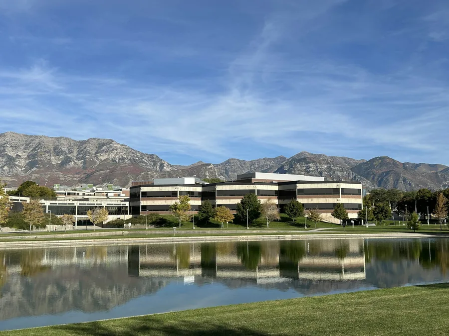 Utah Valley University campus building and pond with mountains behind, Orem, Utah