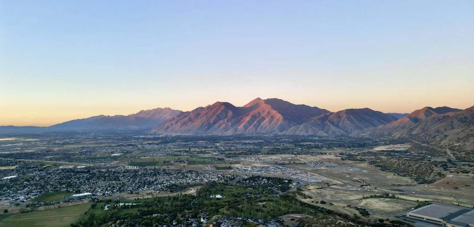 Aerial view of Spanish Fork, Utah, with mountains glowing at sunset