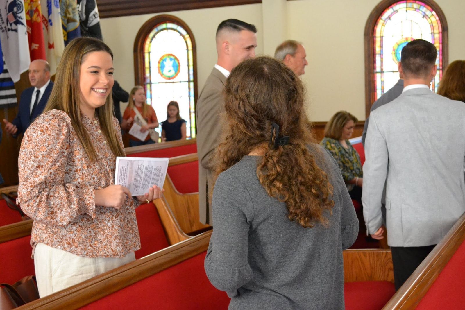Members greeting one another in the pews