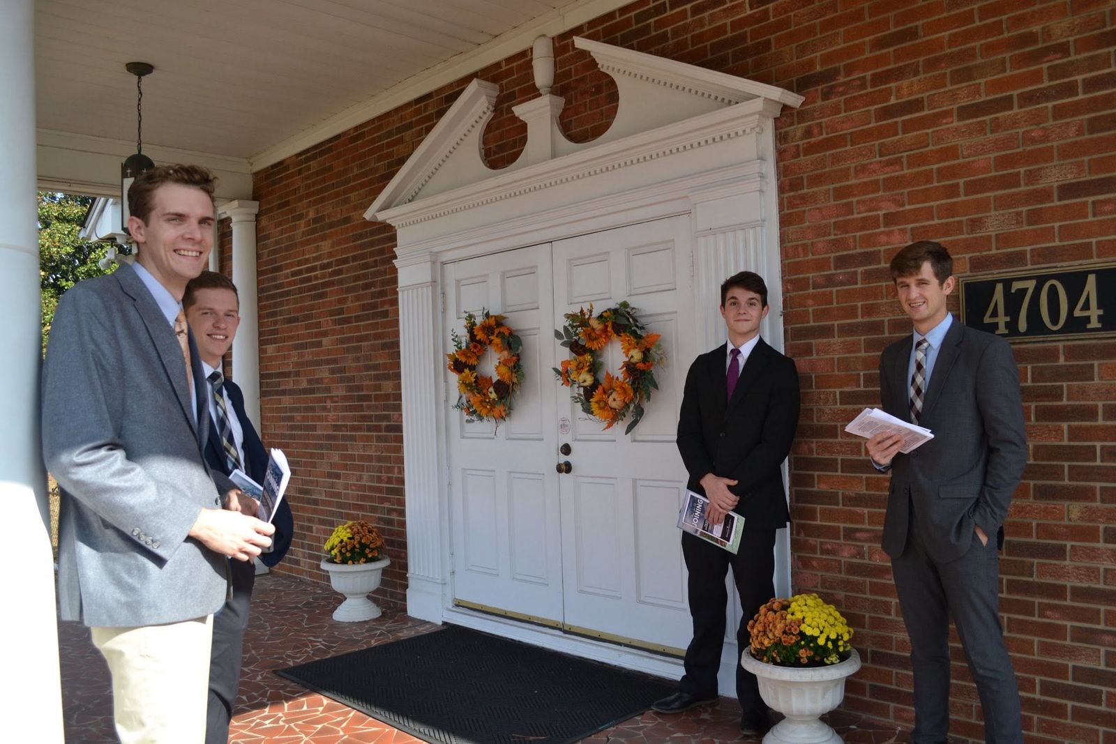 Greeters at the front doors beside the 4704 address plaque