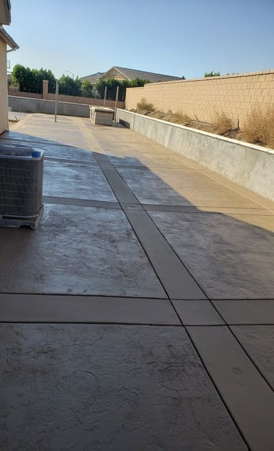 A large residential stamped concrete patio featuring decorative patterns