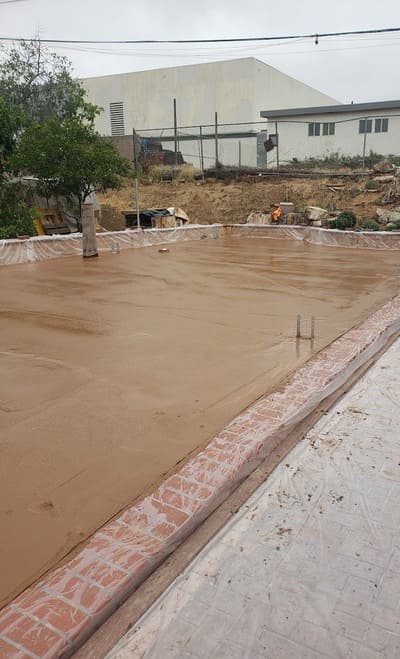 A spacious outdoor patio featuring freshly sealed concrete