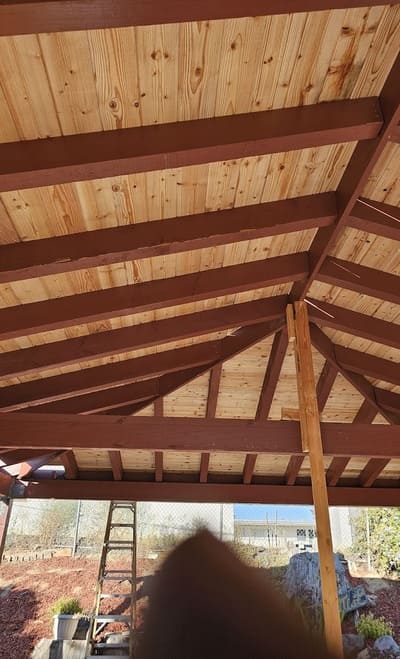 A beautiful wooden patio cover with exposed beams