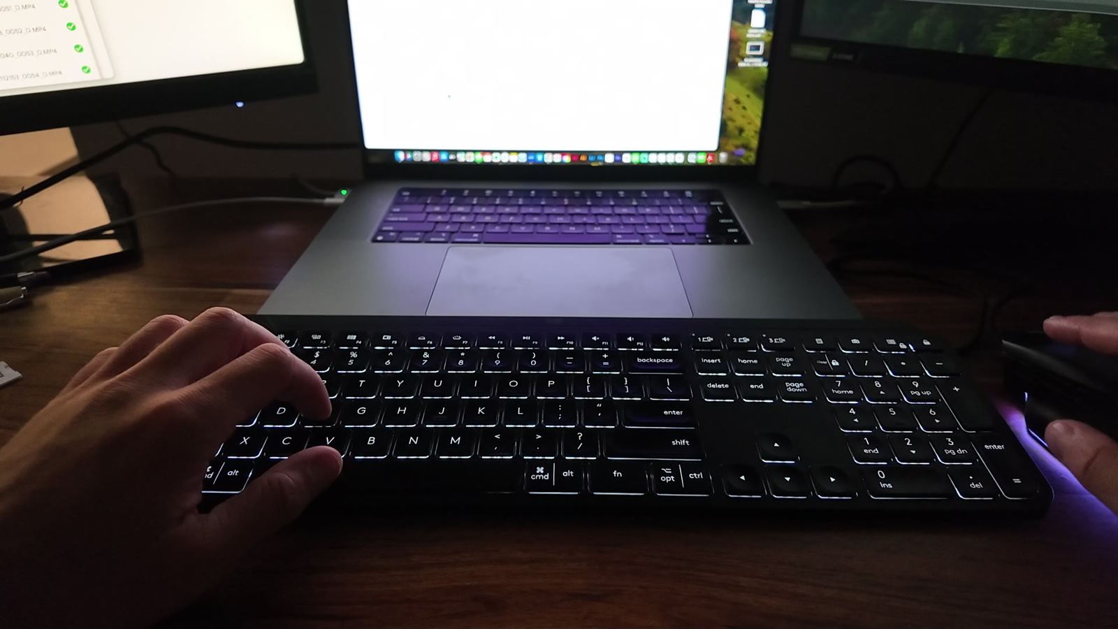 Hands on a keyboard at a desk with a laptop