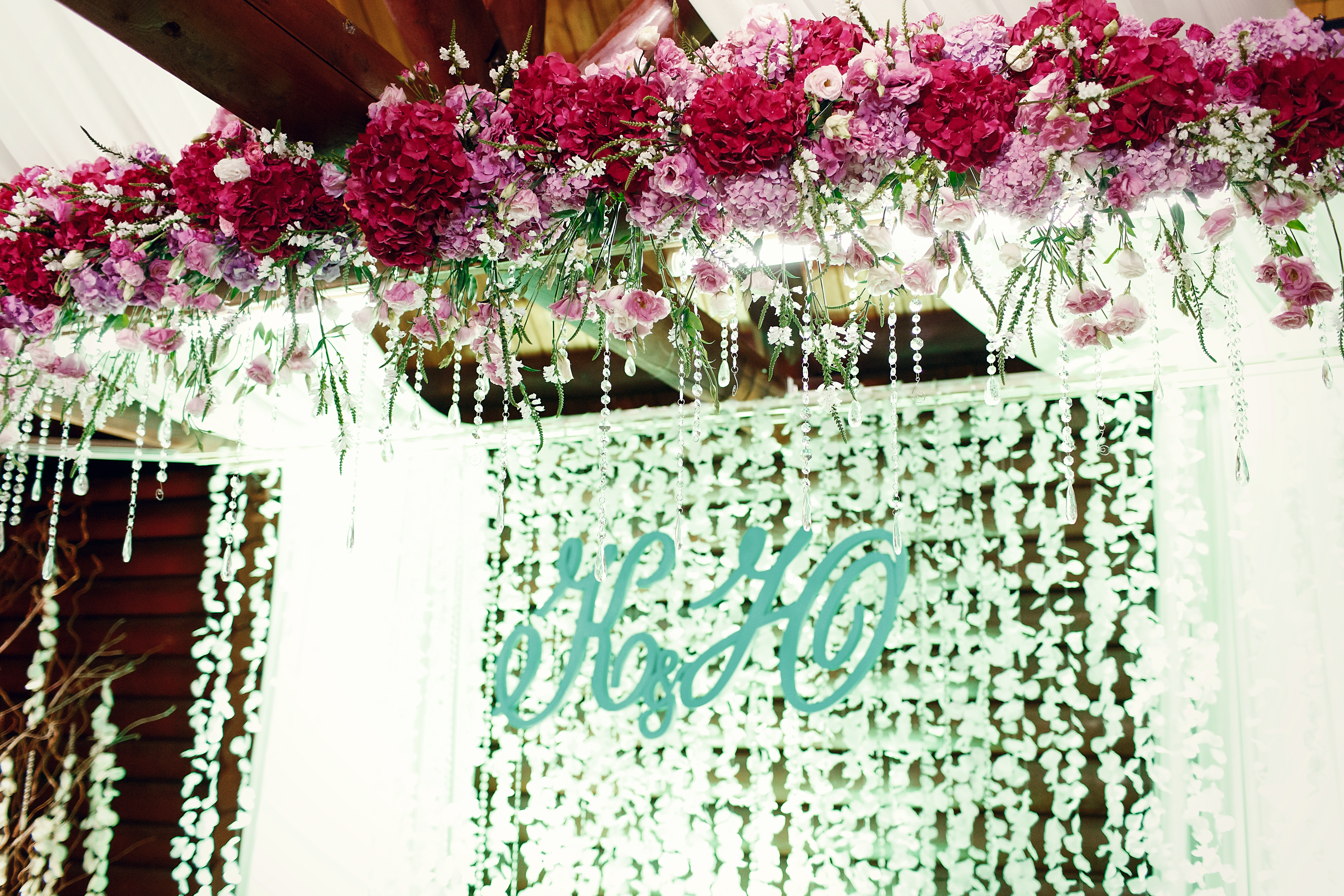 Elegant event table with a tall floral centerpiece and draped curtains