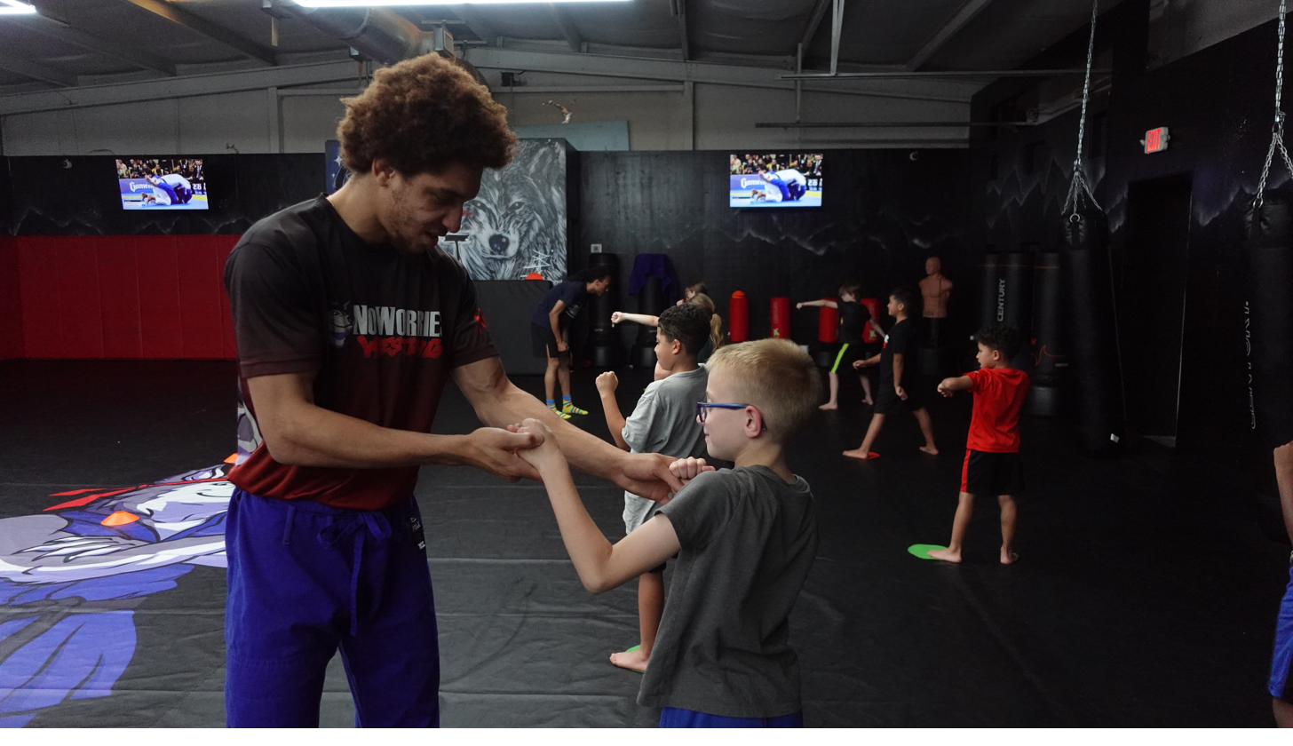 Coach correcting striking technique with youth student