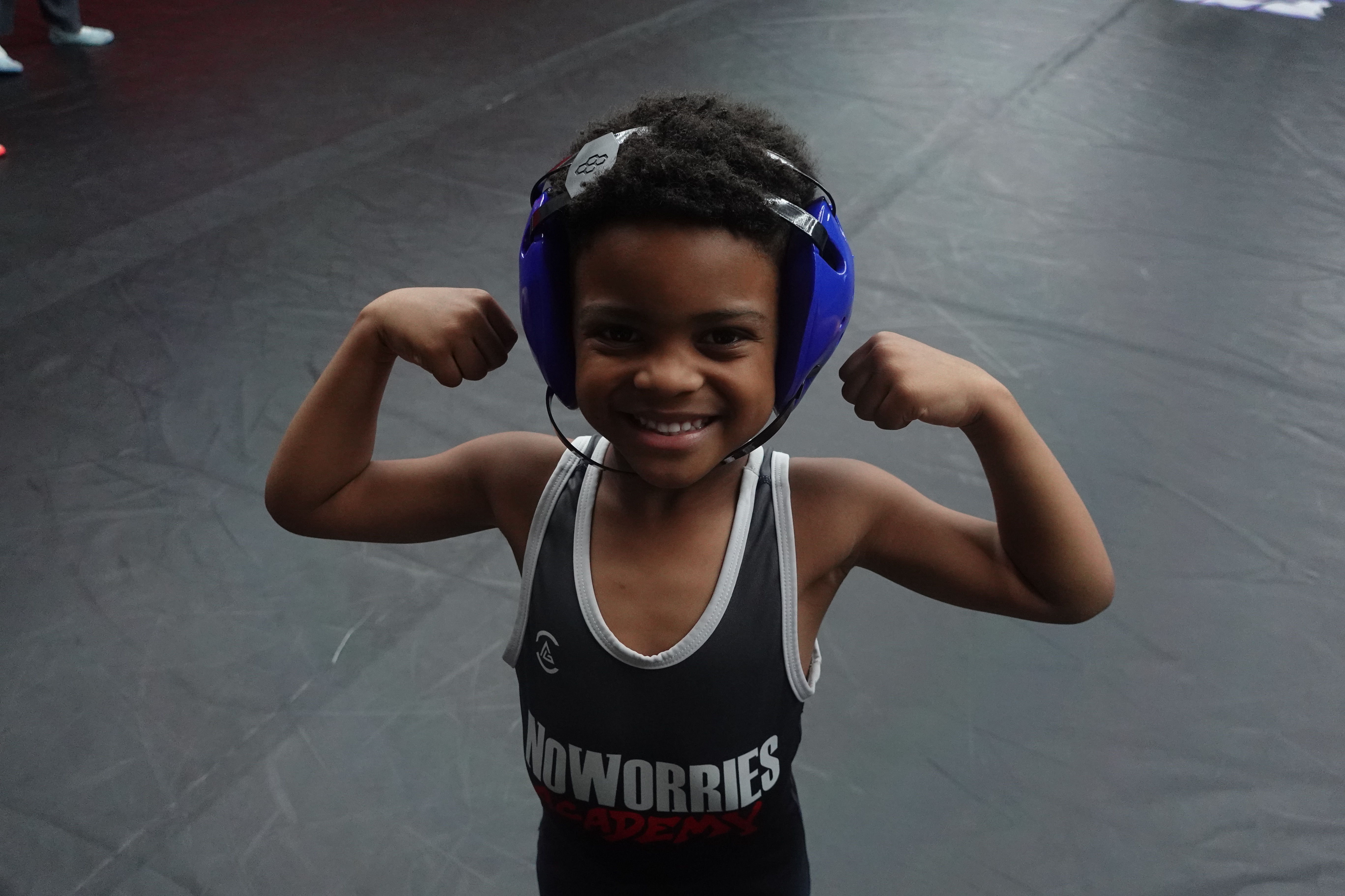 Young NoWorries Academy wrestler flexing with confidence