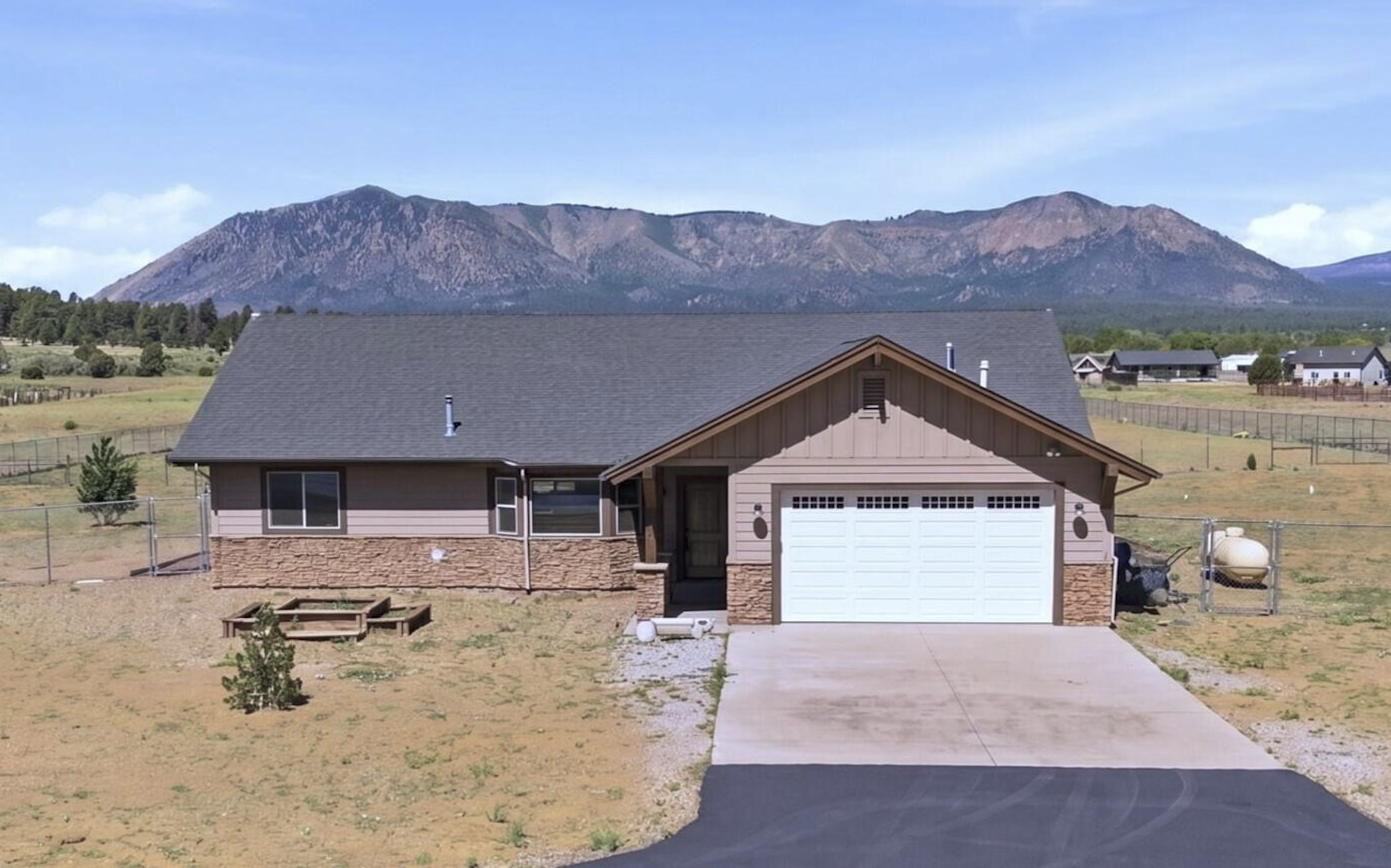 Flagstaff AZ mountain-style home exterior with pine forest backdrop. Flagstaff AZ mountain-style home exterior with pine forest backdrop.