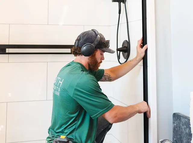 Bath Experts installer fitting a shower wall