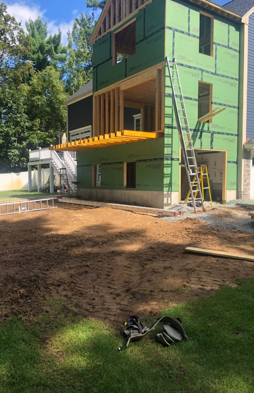 Deck construction in progress by McCarthy Exteriors LLC at a residential property in Brookline, NH