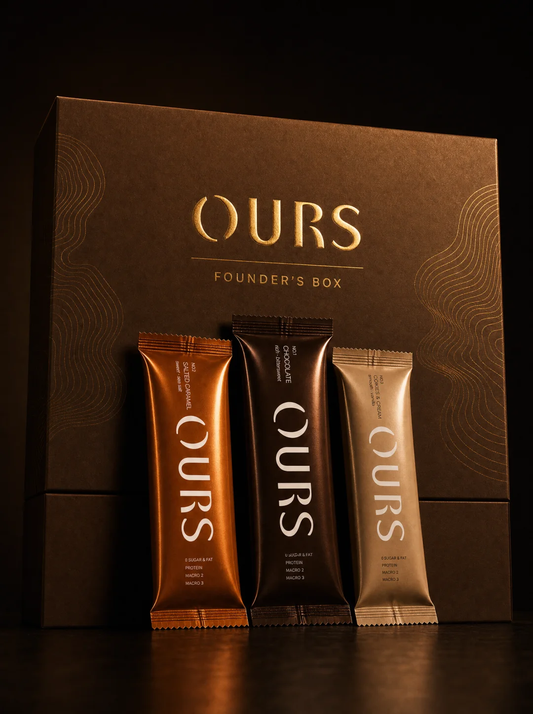 The OURS Founders Box with the three bar flavors standing in front of it