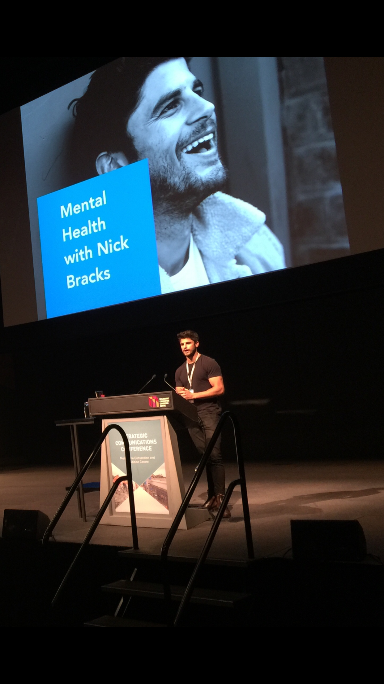 Nick Bracks speaking on stage