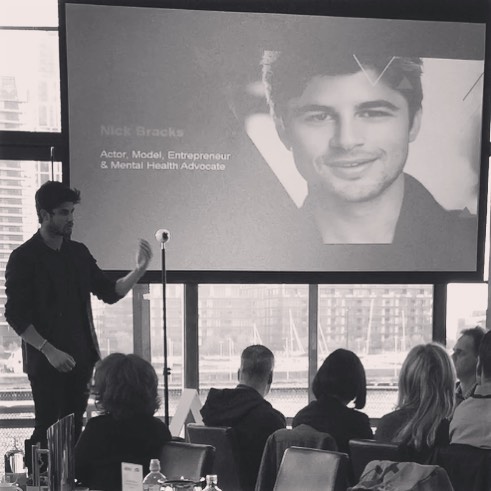 Nick Bracks speaking on stage