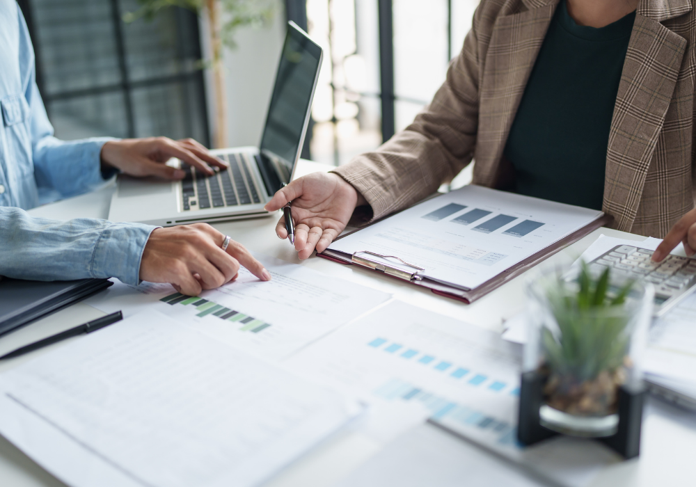 Business owner reviewing bookkeeping software and financial reports with professional notes