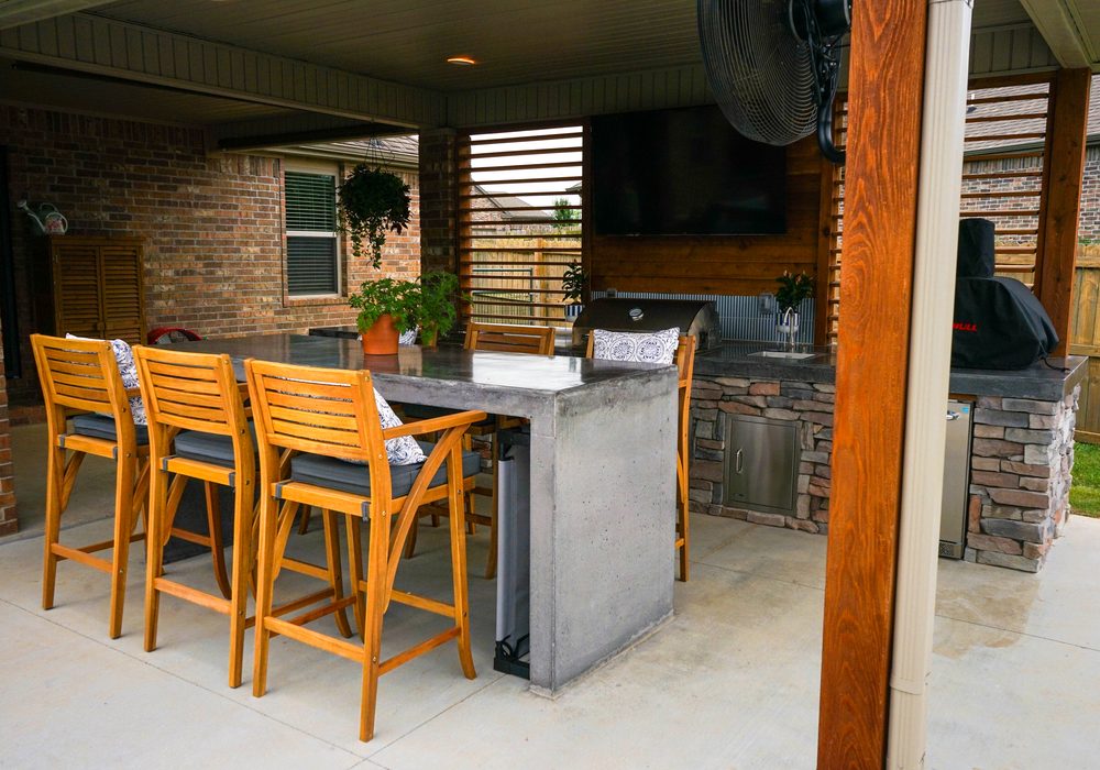 Outdoor bar seating at a concrete top kitchen island